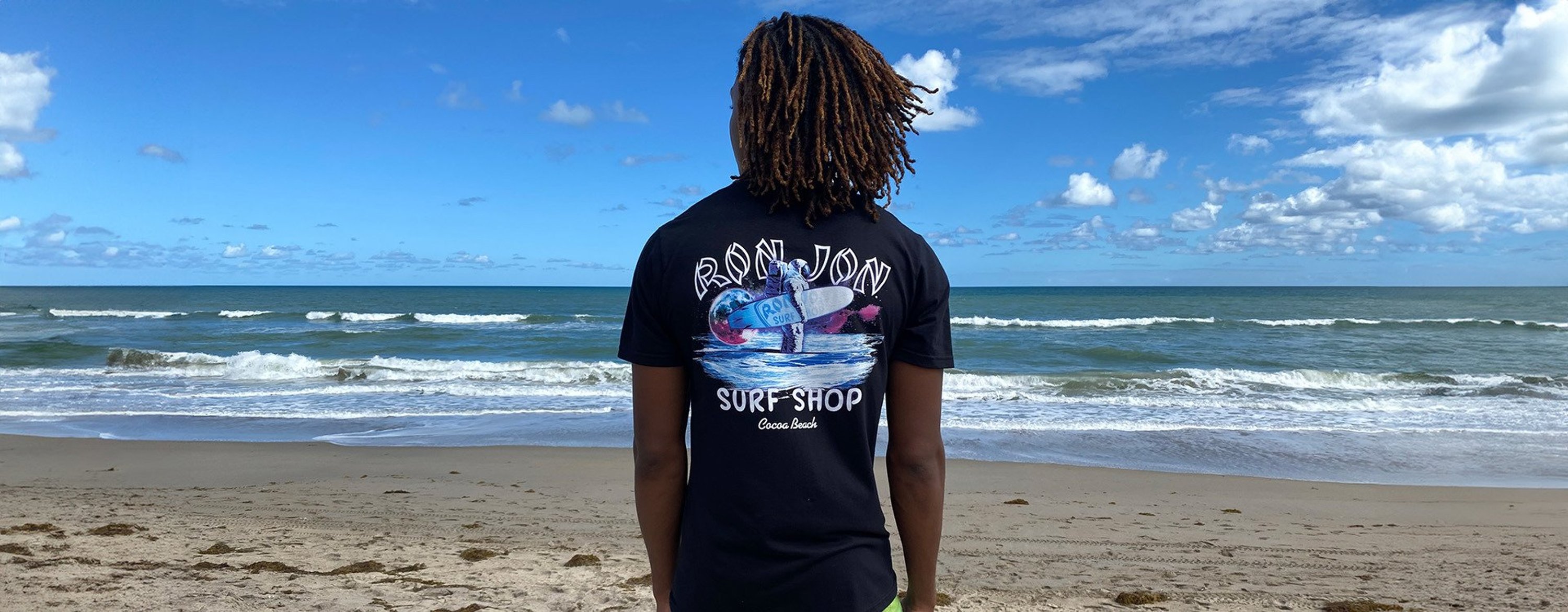 guy on the beach looking out to the ocean wearing galaxy surf tee