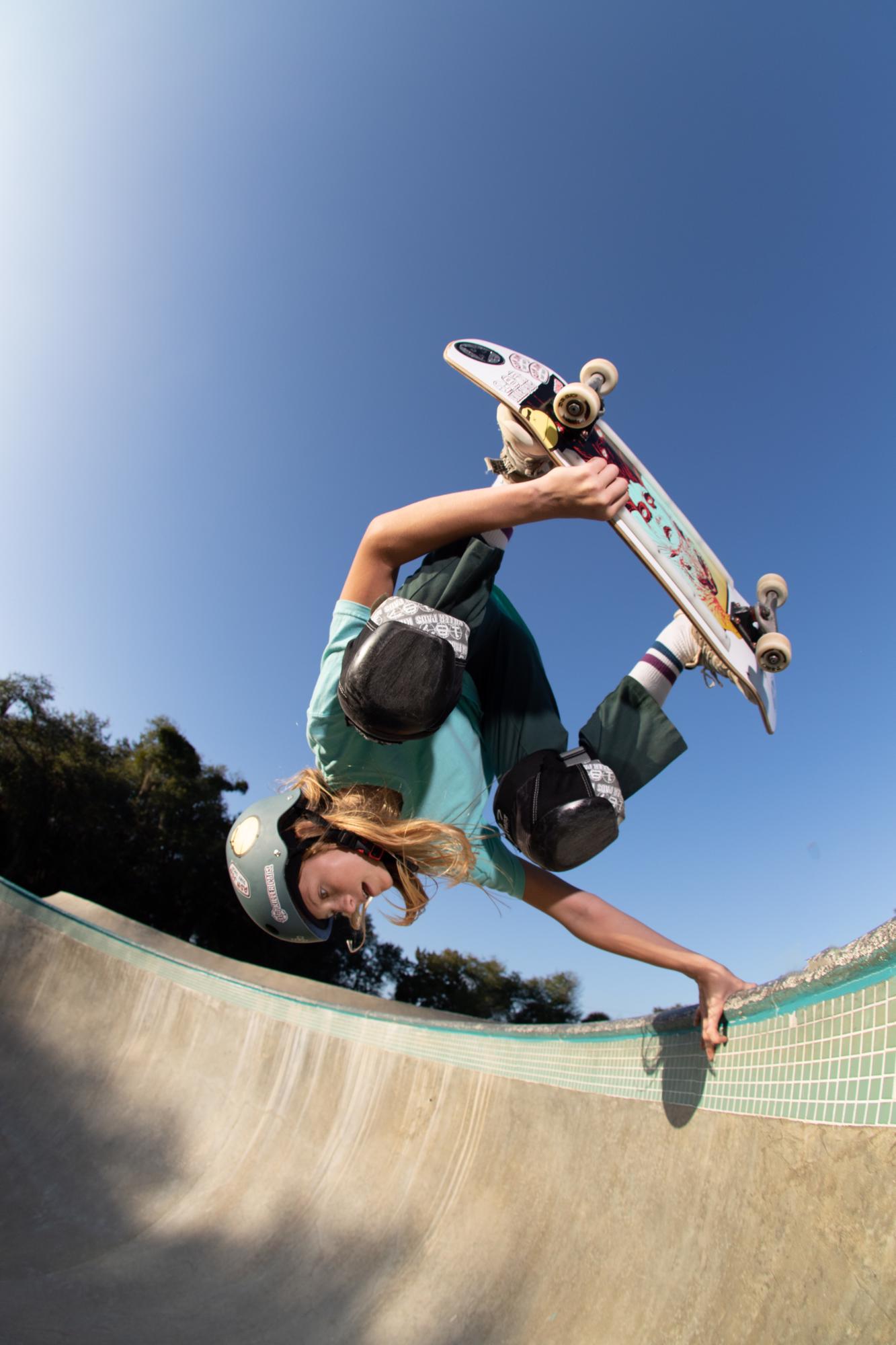 Photo of team rider Harlow Johnsey doing a hand stand while skateboarding