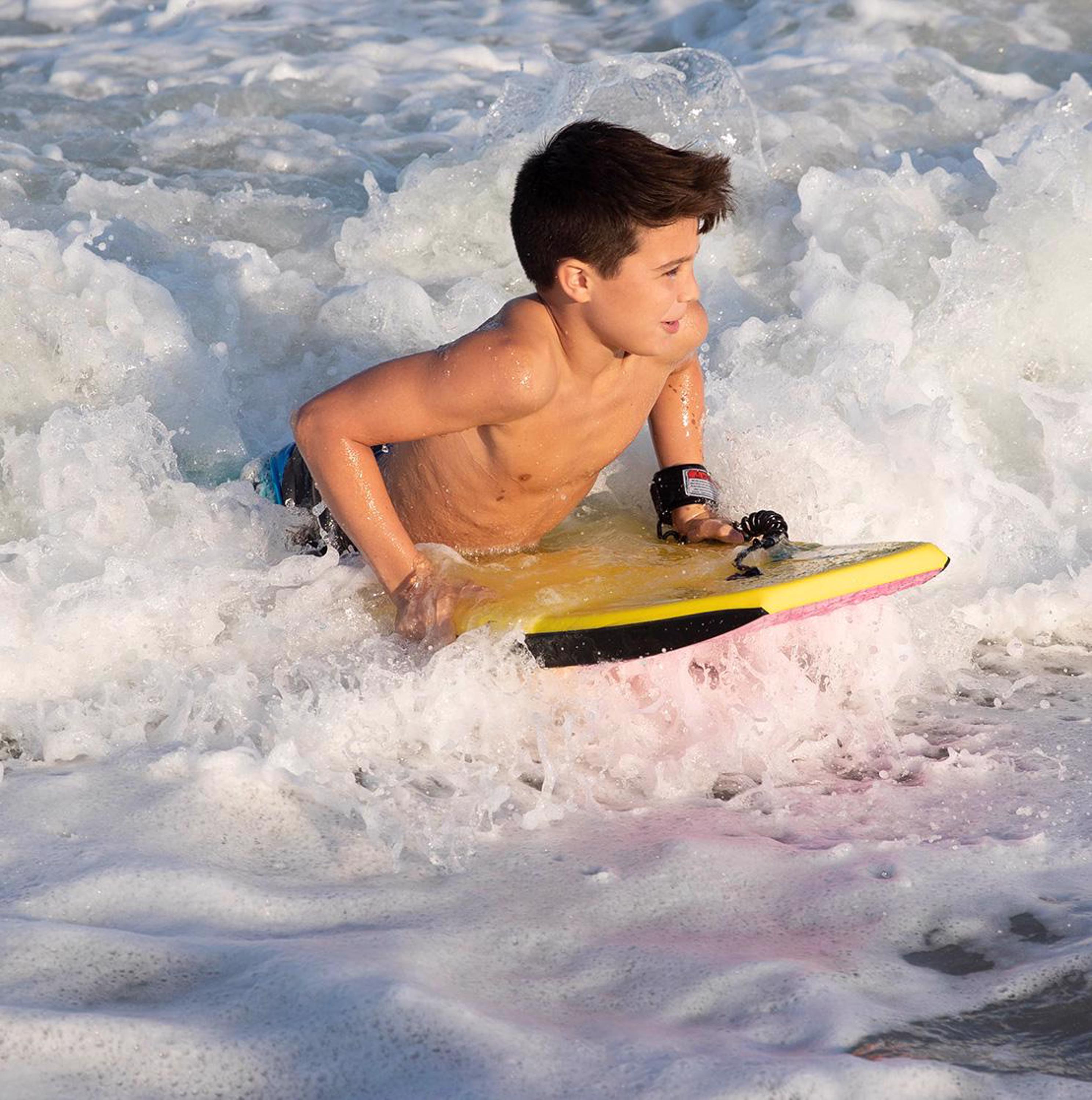 young kid riding a bodyboard