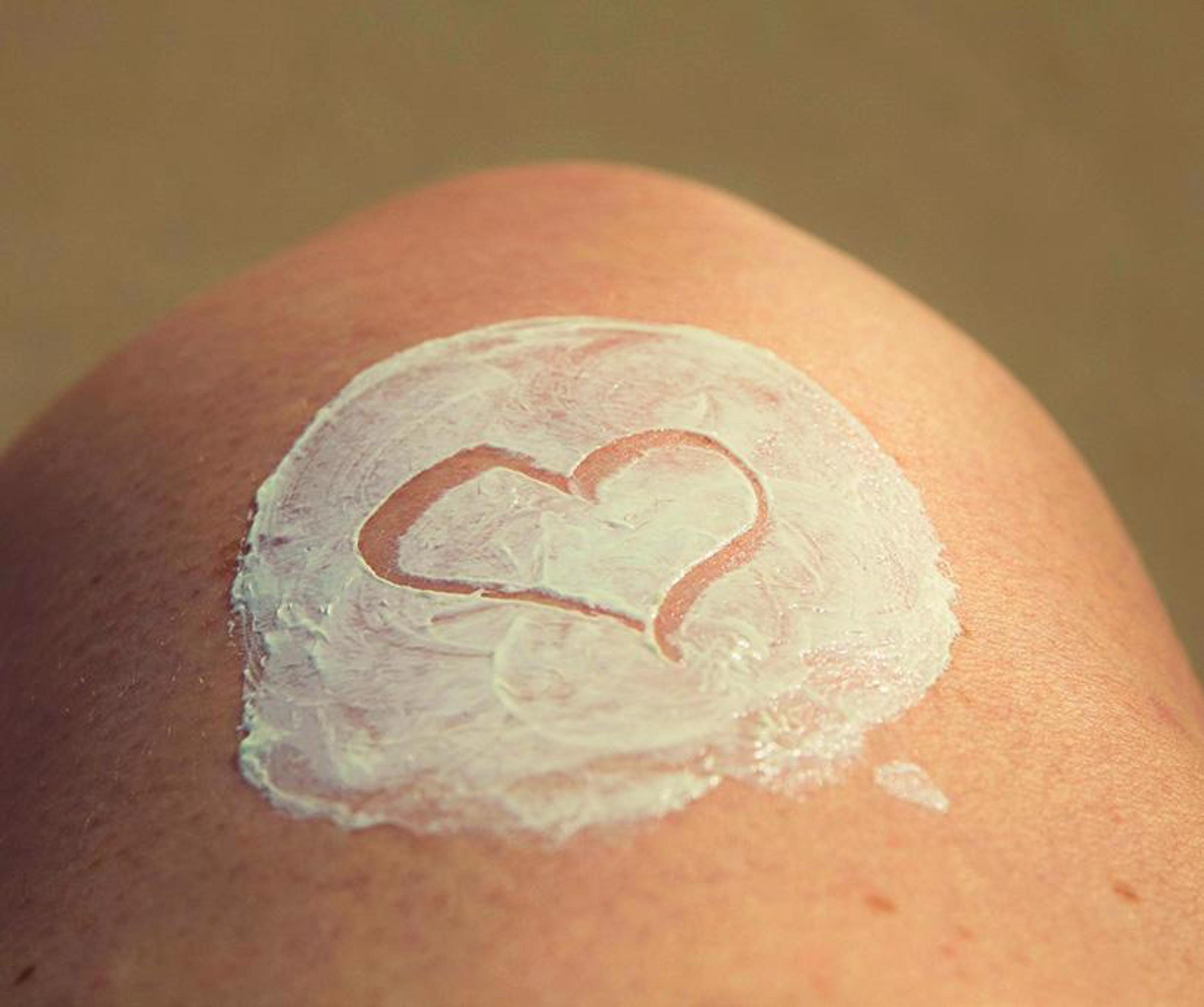 persons knee with heart drawn in lotion
