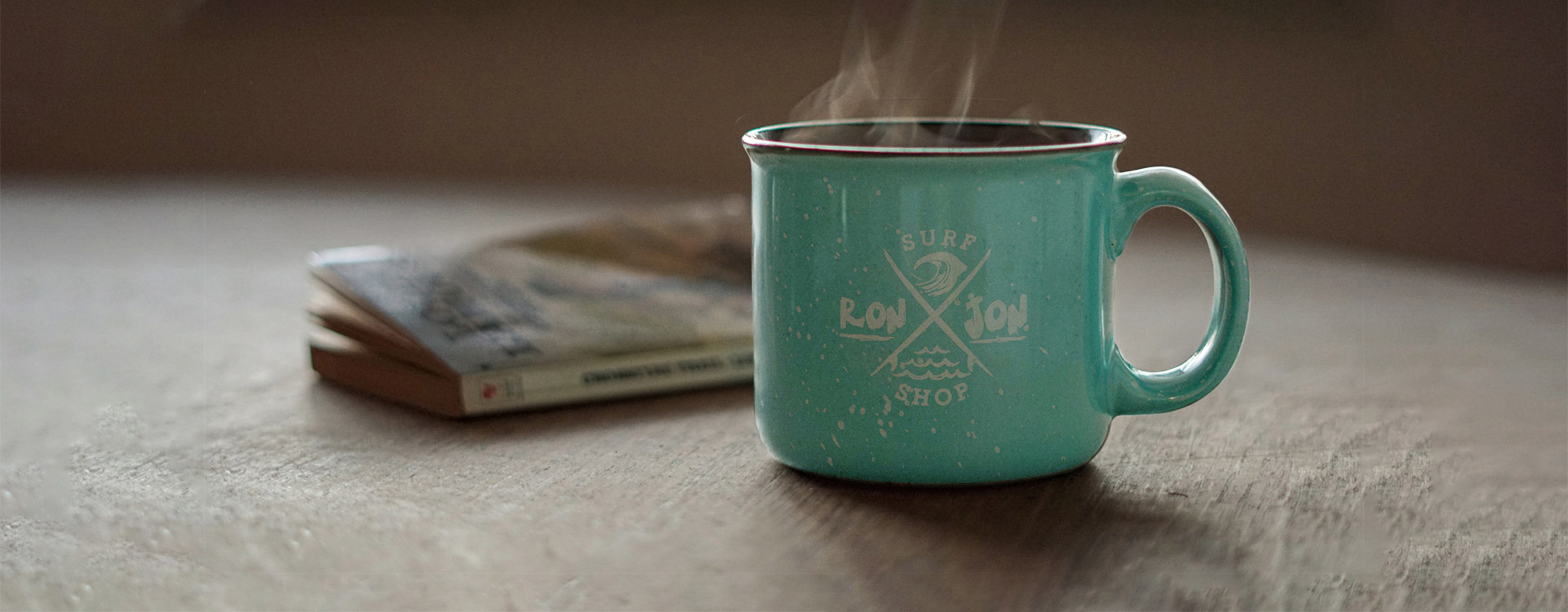 mug with steam on a table with a book in the background