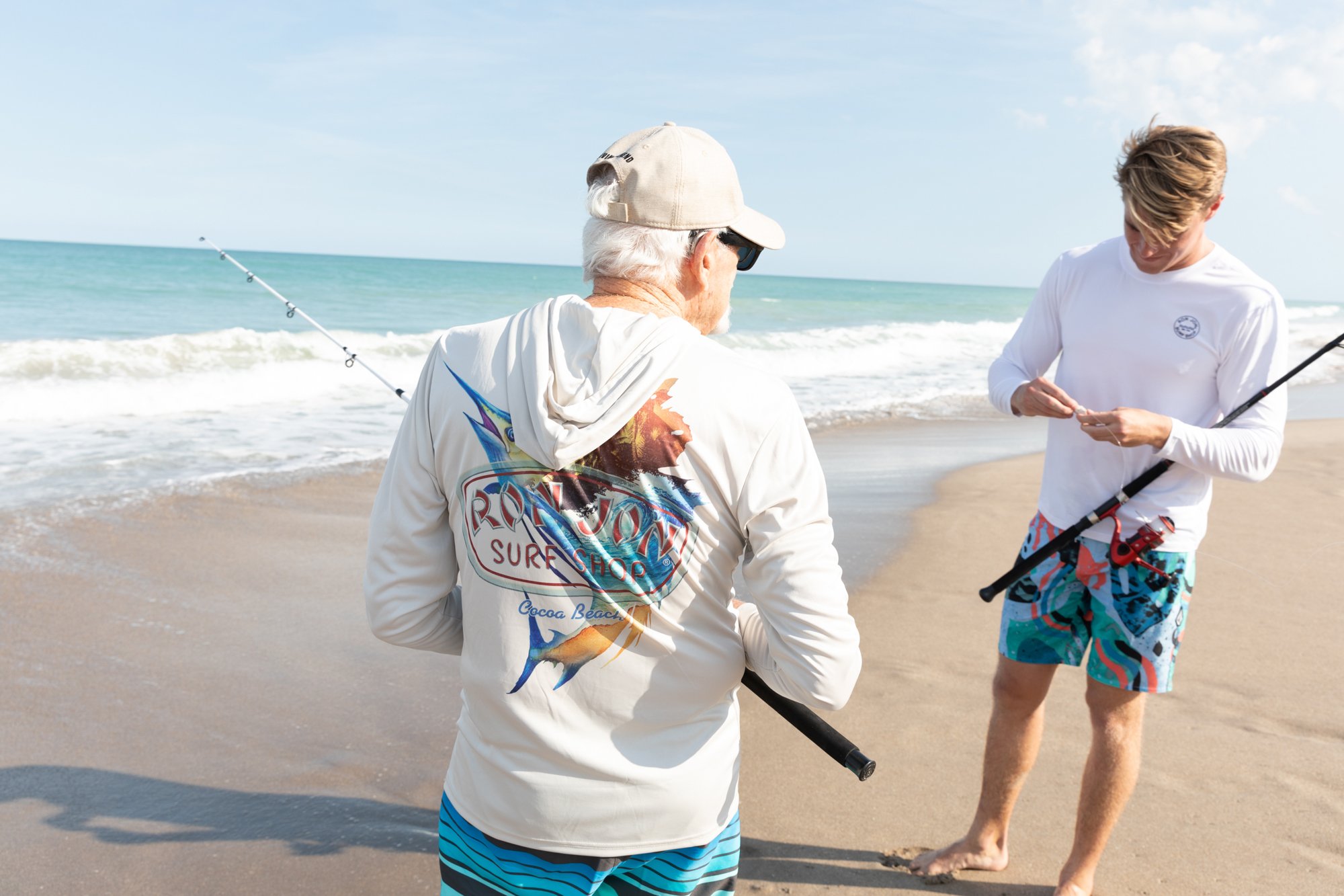 2 guys fishing on the beach in sunshirts