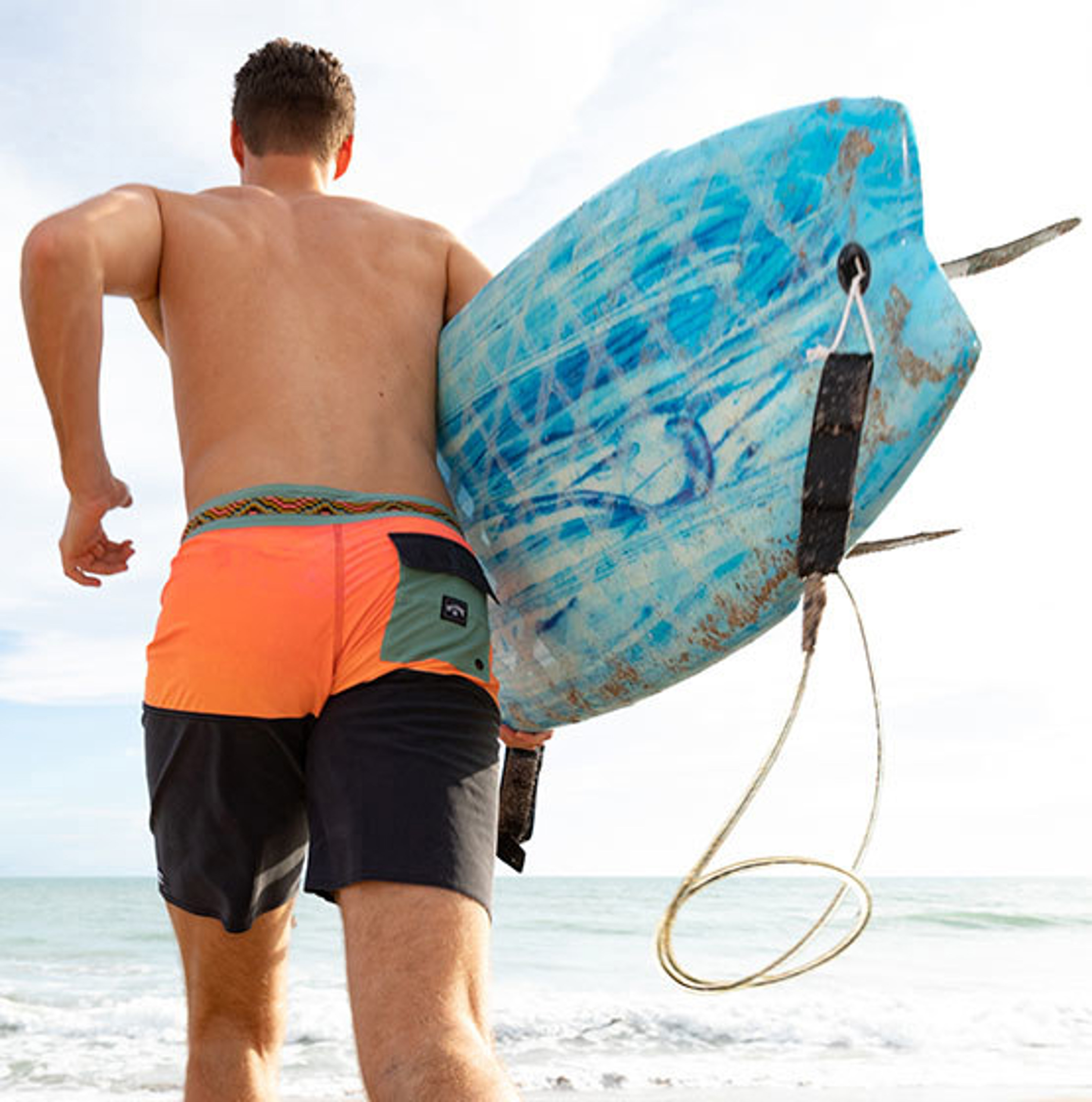guy carrying surfboard with leash
