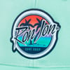 A green fabric featuring a circular Ron Jon Surf Shop logo with palm trees and a sunset background.