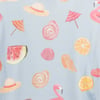 A light blue fabric with a printed pattern of summer hats, umbrellas, orange slices, watermelon, croissants, seashells, and pink flamingos.