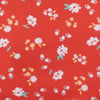 Red background with a pattern of small white and yellow flowers scattered across the surface.