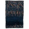 A folded dark blue fabric with tan leaf and vine patterns, featuring fringes along one edge.