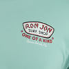 Close-up of a green-colored t-shirt featuring a Ron Jon Surf Shop logo with the phrases One of a Kind and Cocoa Beach, Fla. printed on the chest.