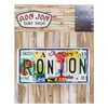 A metal sticker features the words RON JON spelled out with letters from different state license plates, displayed on wood-patterned packaging labeled Ron Jon Surf Shop.