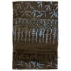A folded dark brown fabric with blue batik-style leaf and heart patterns, featuring a fringe at one end.