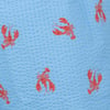 Light blue textured fabric with a repeating pattern of small red lobsters printed across the surface.
