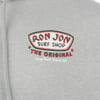 Close-up of a gray hoodie with a Ron Jon Surf Shop The Original Long Beach Island, NJ logo printed on the fabric.