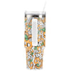A tall travel tumbler with a white handle, transparent lid, and straw, decorated with an orange, green, and white floral and citrus fruit pattern.