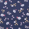 A dark blue fabric with a pattern of small white, yellow, and pink flowers scattered across the surface.