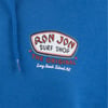Close-up of a blue hoodie with a Ron Jon Surf Shop The Original Long Beach Island, NJ logo printed on the fabric.
