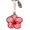 A keychain with a pink hibiscus flower charm and a small silver Ron Jon tag attached to a metal chain.