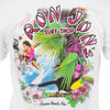 A colorful t-shirt design with Ron Jon Surf Shop text, a surfer on a wave, tropical flowers, a toucan, a cockatoo, and Cocoa Beach, Fla. at the bottom.