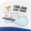 Cartoon pelican surfing on a blue wave, wearing sunglasses, with the text RON JON SURF SHOP above, printed on a white and blue fabric surface.