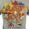 T-shirt with Ron Jon Surf Shop logo featuring a colorful beach sunrise and text Cocoa Beach, Florida.