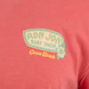 Close-up of a coral-colored shirt with a Ron Jon Surf Shop logo and Cocoa Beach text, featuring a hibiscus flower motif.