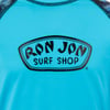 Close-up of a blue shirt featuring the black logo Ron Jon Surf Shop on the chest.