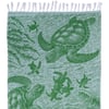 A green towel features an illustration of sea turtles swimming among seaweed, with fringe along the top edge.