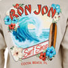 Beige sweatshirt featuring a colorful design with a wave, surfboard, and flowers, labeled Ron Jon Surf Shop, Cocoa Beach, FL.