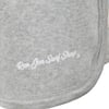 Close-up of a gray fabric with Ron Jon Surf Shop printed in white script near a seam.