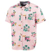 Pink short-sleeve button-up shirt with a tropical print featuring palm trees, flowers, and pineapples.