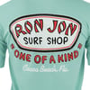 A mint green T-shirt with a large “Ron Jon Surf Shop One of a Kind, Cocoa Beach, Fla.” logo printed on the back.