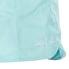 Close-up of a light blue fabric with Ron Jon embroidered in white on the lower right side near a hemmed edge.