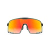 Front view of Knockaround sports sunglasses featuring a single orange-red lens with a black and silver frame.