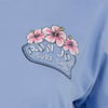 A blue shirt with a Ron Jon Surf Shop logo, featuring pink hibiscus flowers above the text.