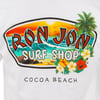 A Ron Jon Surf Shop logo featuring ocean waves, a sunset, palm trees, and tropical flowers. Text reads Cocoa Beach.