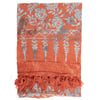 A folded orange sarong with blue floral and geometric patterns and a fringe border at one end.