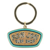 A keychain with a metal ring and a sign that reads Ron Jon Surf Shop in stylized letters on enamel resembling sand, bordered by blue and green.