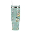 A tall, light green tumbler with a clear lid and straw, decorated with whimsical flowers, bees, mushrooms, and playful graphic designs.