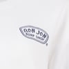 White shirt with a blue embroidery reading RON JON SURF SHOP on the upper left chest.