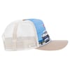 A mesh trucker hat with a beige brim, light blue front panel featuring a printed image of a pier scene, and white mesh sides and back.