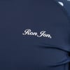 Close-up of a dark blue fabric featuring the Ron Jon logo in white script.