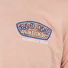 Close-up of a light brown shirt featuring a Ron Jon Surf Shop logo above Pensacola Beach text.