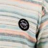 Close-up of a multicolored striped fabric with a Ron Jon Surf Shop patch sewn on.