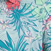 Close-up of a colorful tropical shirt with floral and foliage patterns featuring a visible Ron Jon Surf Shop logo.