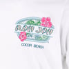 White shirt with a Ron Jon Surf Shop Cocoa Beach logo, featuring pink hibiscus flowers and green leaves.