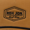 A brown fabric with a black Ron Jon Surf Shop logo embroidered in a hexagonal shape.