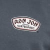 Close-up of a Ron Jon Custom Surfboards logo on a dark fabric background.