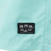 Close-up of a turquoise fabric featuring a black label with a palm tree design and the words Ron Jon Surf Shop in white.