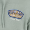 Close-up of a teal hoodie featuring the Ron Jon Surf Shop logo with Cocoa Beach text underneath.