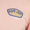 Peach shirt with a Ron Jon Surf Shop Ft. Myers logo in blue, white, and tan printed on the upper left chest.