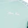 Close-up of a light turquoise shirt with Ron Jon printed in white cursive letters on the chest.